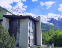 a large brick building with a mountain in the background