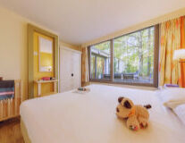 a bedroom with a stuffed animal on a bed