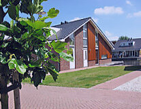 a large brick building with grass and trees