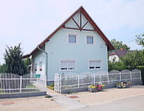 a house with a fence in front of a building