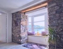 a stone fireplace is next to a window