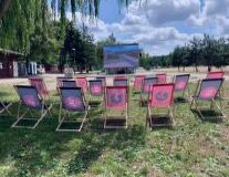 a group of lawn chairs sitting on top of a grass covered field