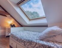 a double bed in a bedroom next to a window
