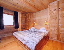a bedroom with a bed that is made out of wood