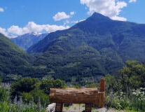 a wooden bench sitting in front of a mountain