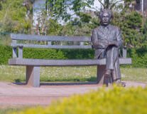 a statue of a person sitting on a park bench
