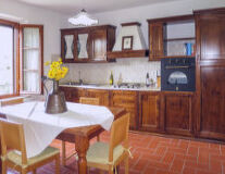 a kitchen with wooden furniture and vase on a table