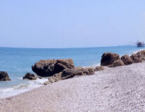 a rocky beach next to a body of water